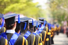 A lot of master graduates standing next to each other festive uniforms