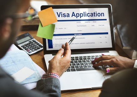 Two people entering data in a United States Visa Application