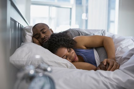 A couple cuddling in bed.