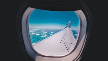 A view from an airplane window with a visible airplane wing