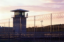 The outside view of a tower and wire fence of a US Criminal Justice system's building