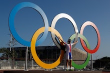 A man posing next to Olympic rings at the 2016 Olympics