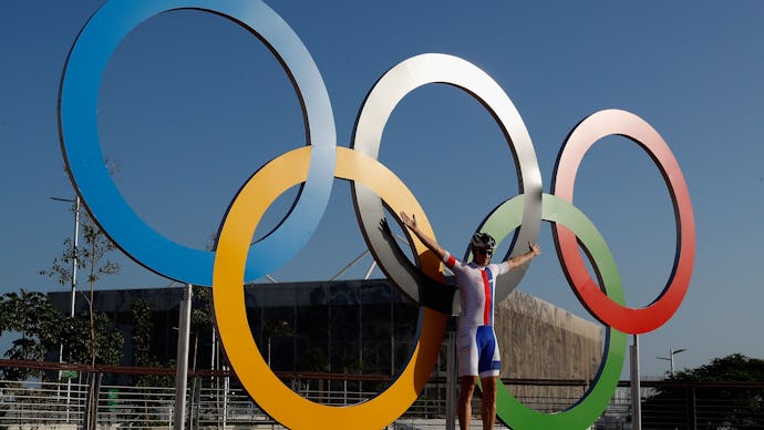 A man posing next to Olympic rings at the 2016 Olympics