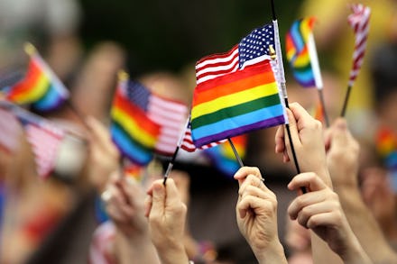 Many hands waving small USA and LGBT flags