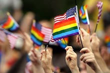 Many hands waving small USA and LGBT flags