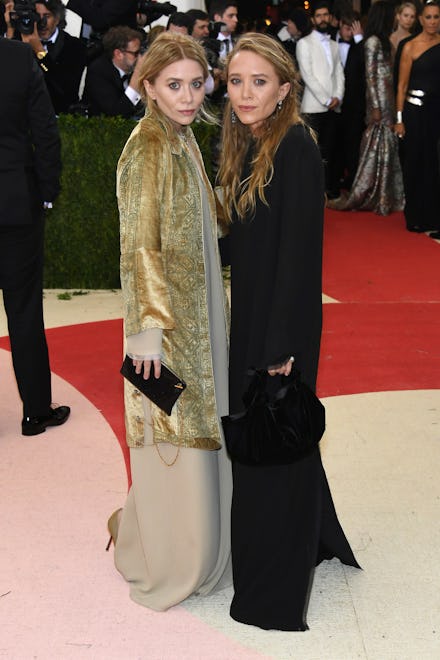 Mary-Kate and Ashley Olsen on a red carpet event wearing contrasting color outfits