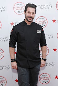 Chef Johnny Iuzzini posing in a black kitchen uniform