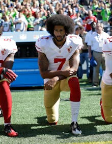 Colin Kaepernick kneeling on a stadium before a football game