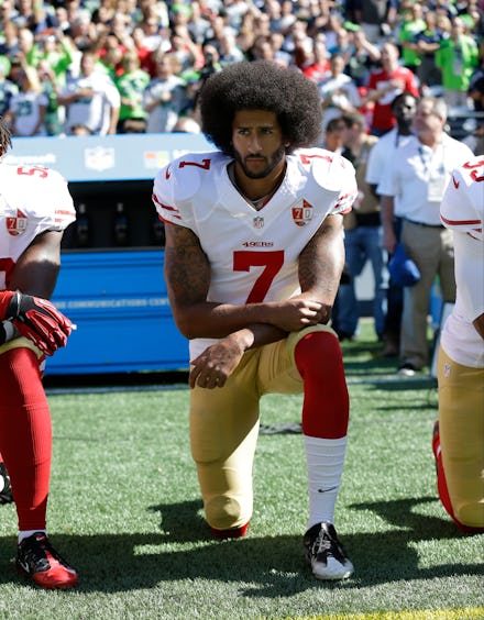 Colin Kaepernick kneeling on a stadium before a football game