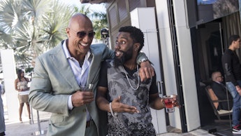 Dwayne Johnson and John David Washington walking and hugging in a scene in Ballers