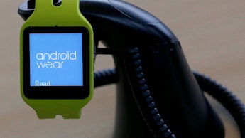 Green smartwatch with "android wear" text on its screen