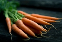 A bunch of freshly harvested carrots on a black surface