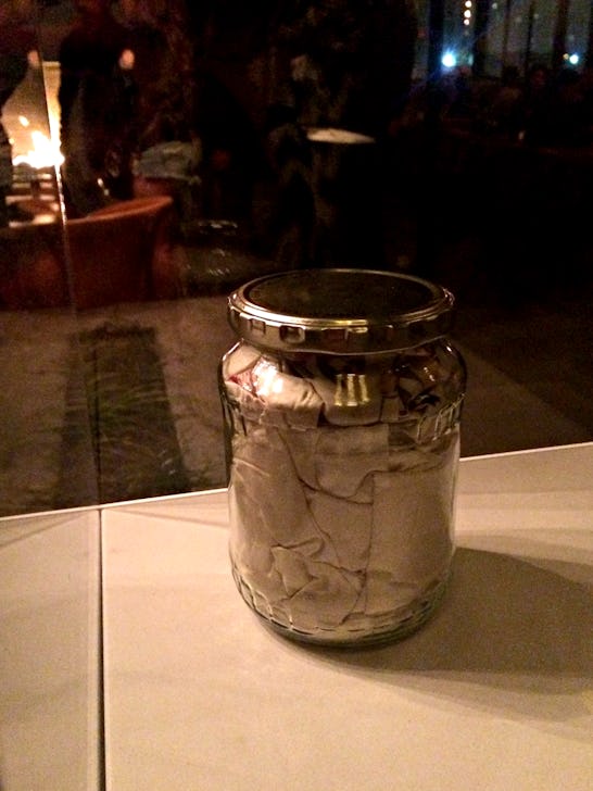 A wedding dress stuffed in an old dill pickle jar