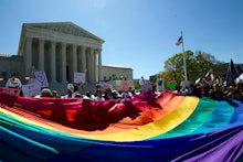 A group of LGBTQ rights protester holding a large flag in front of the U.S. Capitol