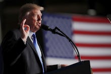 Donald Trump giving a speech with the U.S. flag in the background 