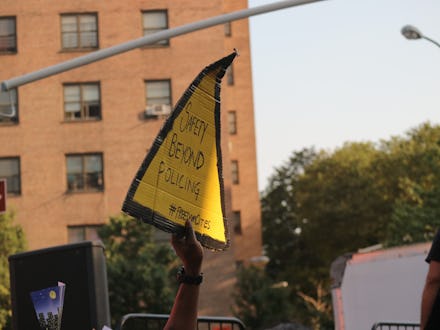 A man holding a yellow sign at the #SafetyIs rally