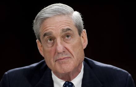 Robert Mueller in a suit, staring above him while being backlit and sitting in front of black backgr...