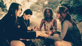 Group of girls sitting in a circle and holding hands