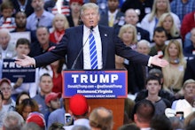 Donald Trump standing at a podium performing a speech in front of his audience