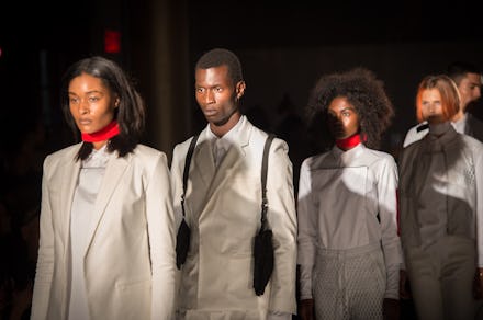 Four models wearing white blazers at a fashion show