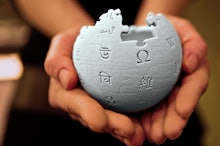 A pair of hands holding the wikipedia logo