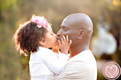 A black father embraces his daughter
