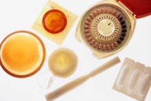 A variety of old-fashioned birth control objects including spirals, IUD-s and pills