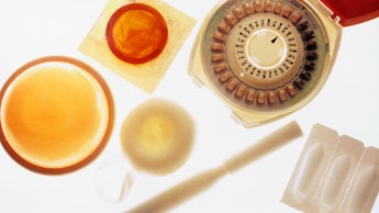 A variety of old-fashioned birth control objects including spirals, IUD-s and pills