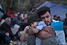 A camp with Syrian refugees; A father holding his son