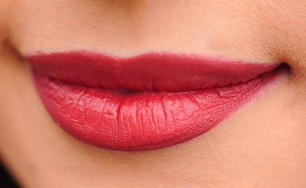 Lips that have undergone plastic surgery with red-toned lipstick on them