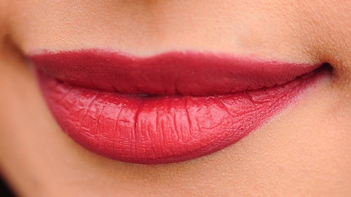 Lips that have undergone plastic surgery with red-toned lipstick on them