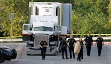 Police officers line up around a large truck smuggling humans