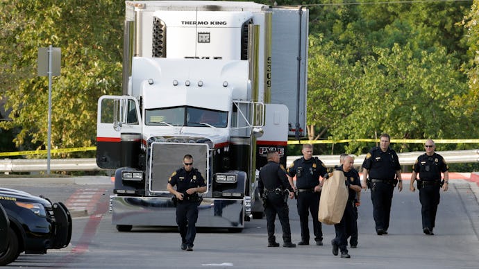 Police officers line up around a large truck smuggling humans