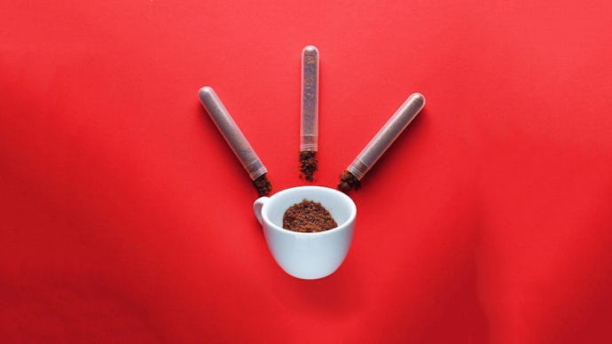 Three small tubes and a white mug with instant coffee in it on a red surface