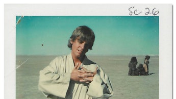 Mark Hamill behind the scenes as luke skywalker posing with his hands put together in front of him