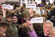 A group of people holding 'Trump' sign papers