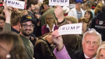 A group of people holding 'Trump' sign papers