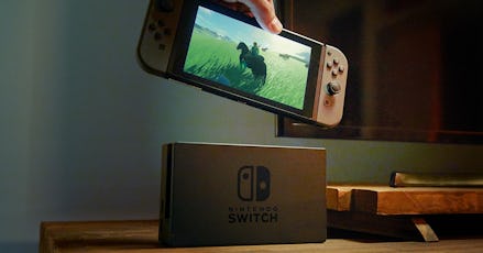 A man holding the Nintendo Switch console in a demo video