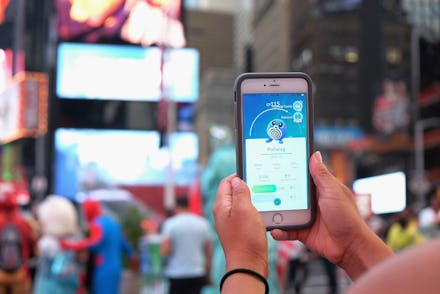 A person playing Pokémon Go on a crowded street