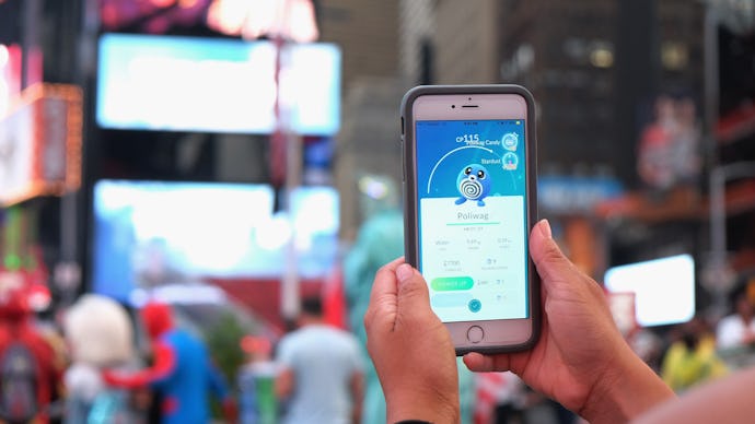A person playing Pokémon Go on a crowded street
