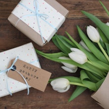 Mother's Day gifts on a table with white tulips on the side