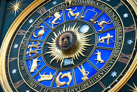 A blue-and-golden zodiac clock with star signs and months of the year