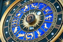 A blue-and-golden zodiac clock with star signs and months of the year