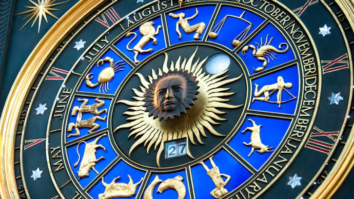 A blue-and-golden zodiac clock with star signs and months of the year