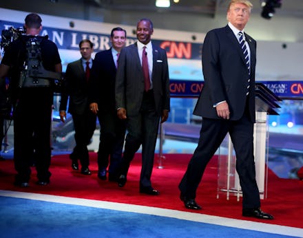 Donald Trump and a group of men walking behind him at the Third Republican Presidential Debate
