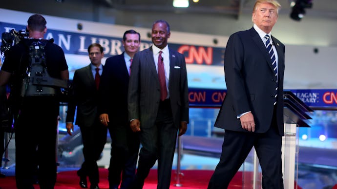 Donald Trump and a group of men walking behind him at the Third Republican Presidential Debate