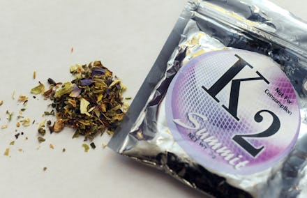 A tin foil bag of synthetic weed with some of it spilling out of the bag