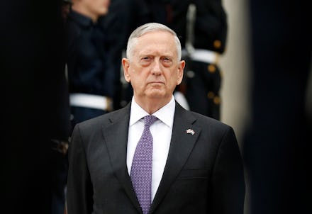 James Mattis standing in a formal suit with a purple tie