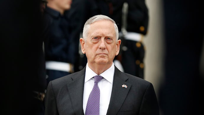 James Mattis standing in a formal suit with a purple tie