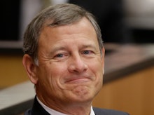 A closeup of Chief Justice John Roberts smirking
